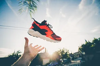 Eine Hand wirft einen Turnschuh, symbolisch für Bewegung oder Neuanfang.