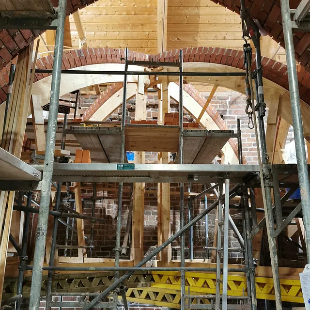 Das Kirchengewölbe im Bau, mit neuem Mauerwerk und Gerüsten.
