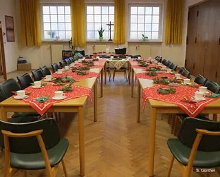Ein festlich dekorierter Kirchensaal mit Tischen für ein Gemeinschaftsessen.