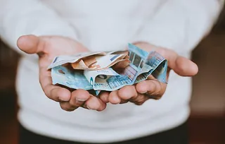 Hände halten Geld, als Symbol für eine Kollekte oder Spende.