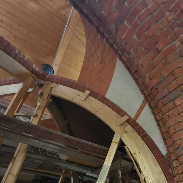 Nahaufnahme eines Backsteinbogens, der in der Kirche renoviert wird.